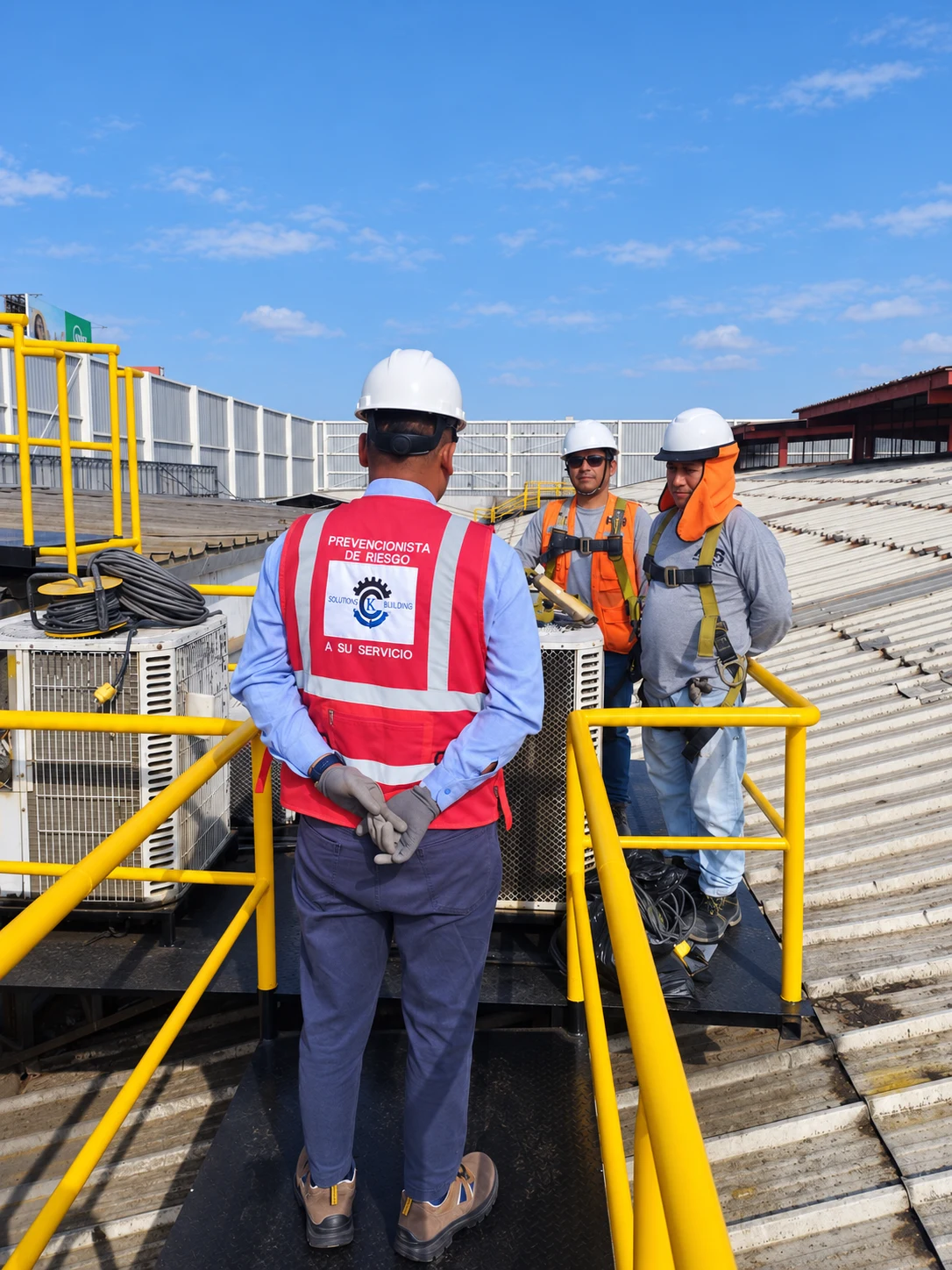 Prevencionista supervisando el mantenimiento de equipos de aire acondicionado sobre una cubierta